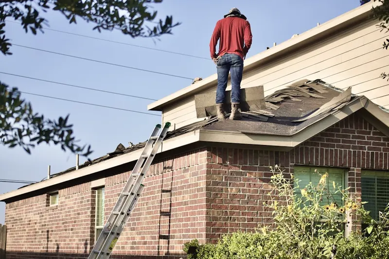 Professional roofer working on a residential roof in Sangree